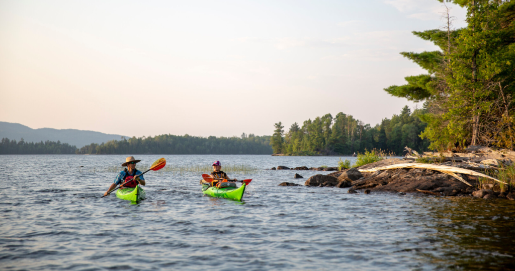 ken whiting and tour guide kayaking in les Laurentides, Québec while the sun is setting paddle tales paddletv facing waves