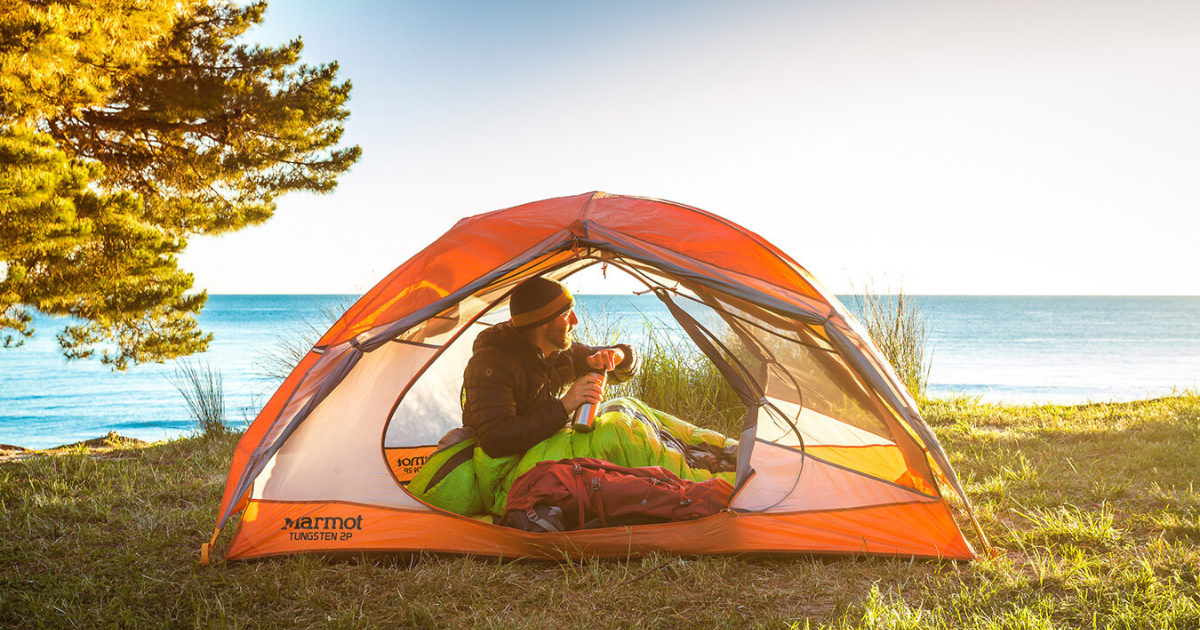eric hanson in a tent over looking the ocean in new zealand backpacking and hiking for beginners