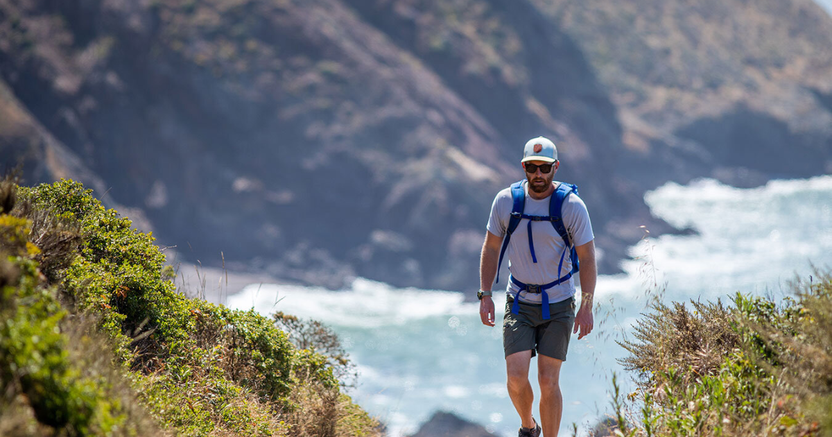 eric with the pacific ocean behind him while hiking and backpacking