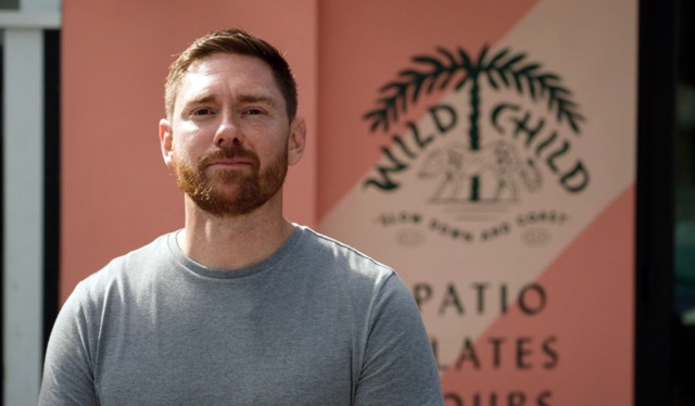 Photo of Head Chef Rob Reinsmith of Wild Child standing in front of his restaurant.