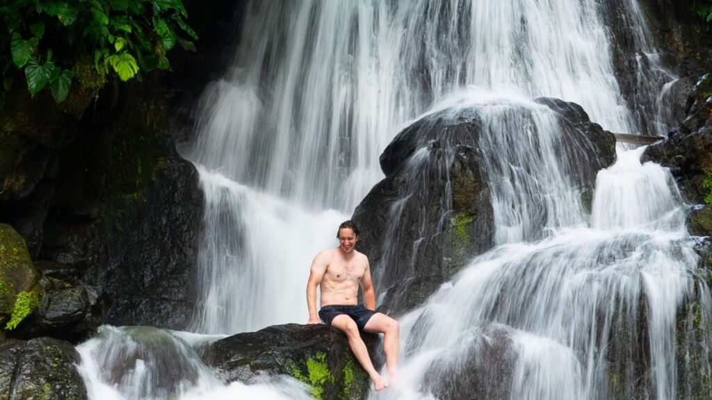Travel Accident Insurance provided by Redpoint Travel Protection, Mike sitting in a 
waterfall