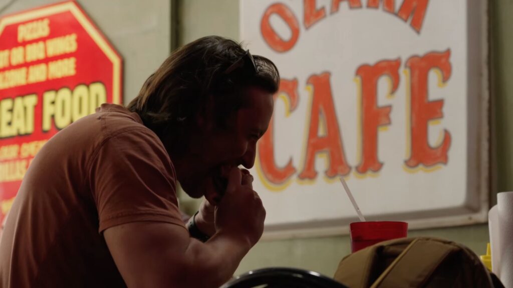 mike biting into burger at ozark cafe in jasper arkansas